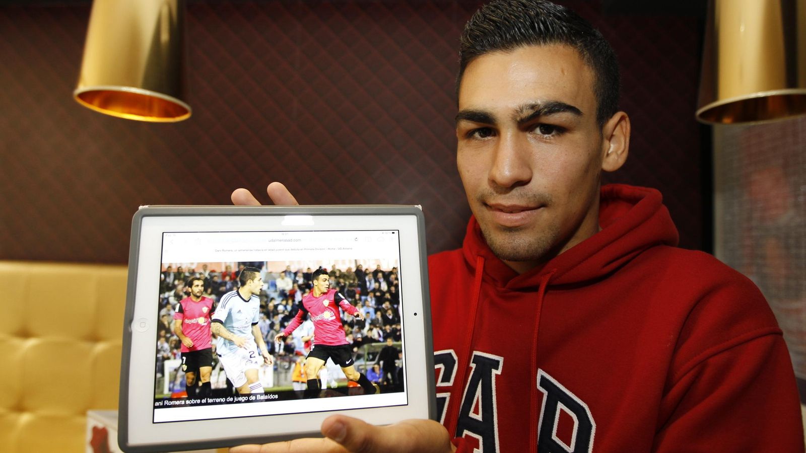 Dani  Romera sostiene un iPad con la imagen de su debut liguero en Primera División.
