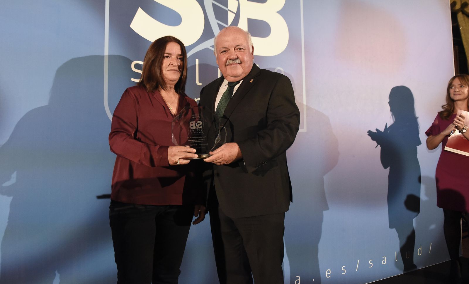 Isabel González, de Anumayores, recogió el galardón de manos del Consejero de Salud, Jesús Aguirre.