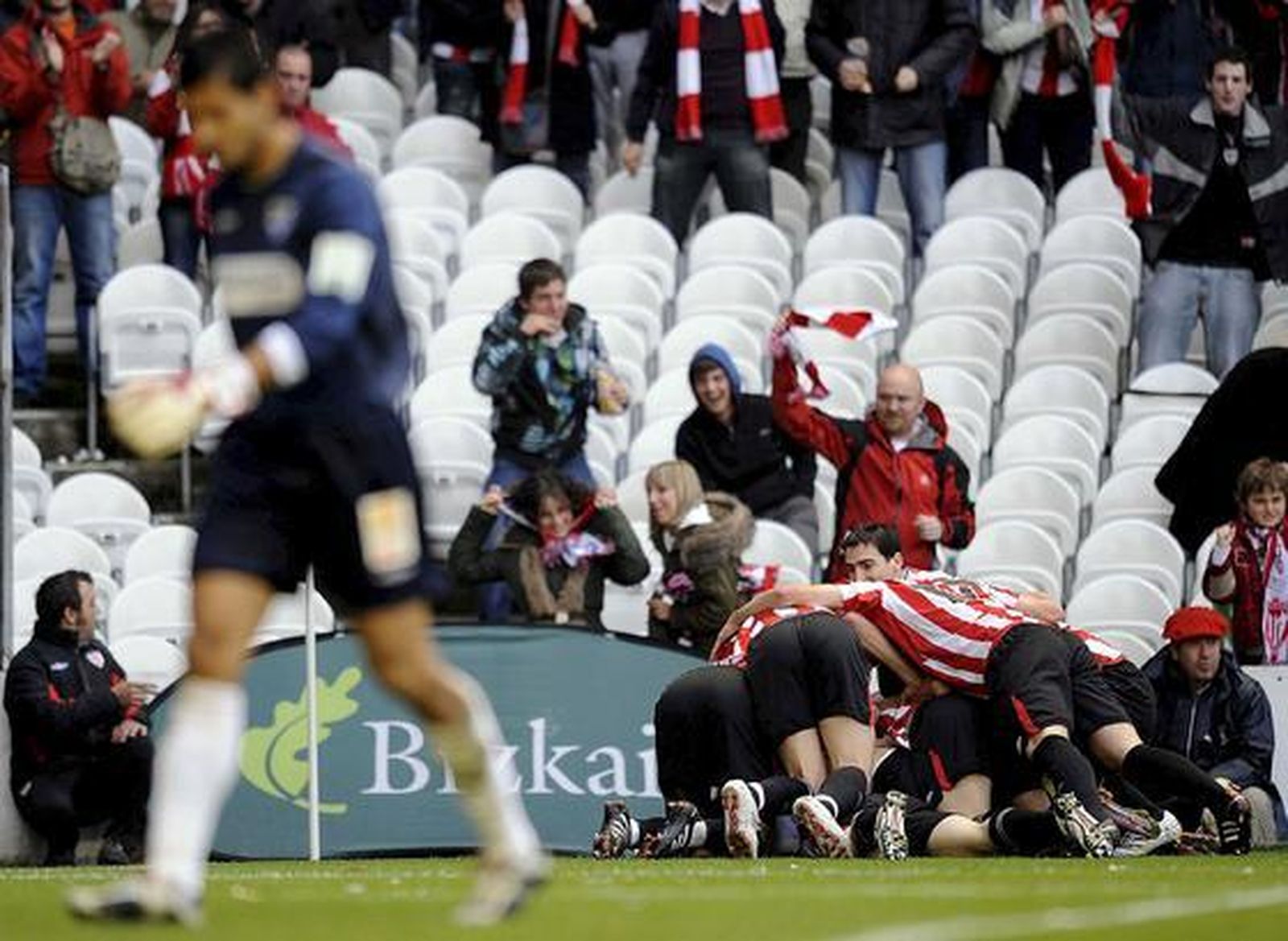 Imagen del portero malaguista Munúa mientras los jugadores locales celebran el tanto conseguido por Toquero.  Foto: EFE/ Miguel Toña