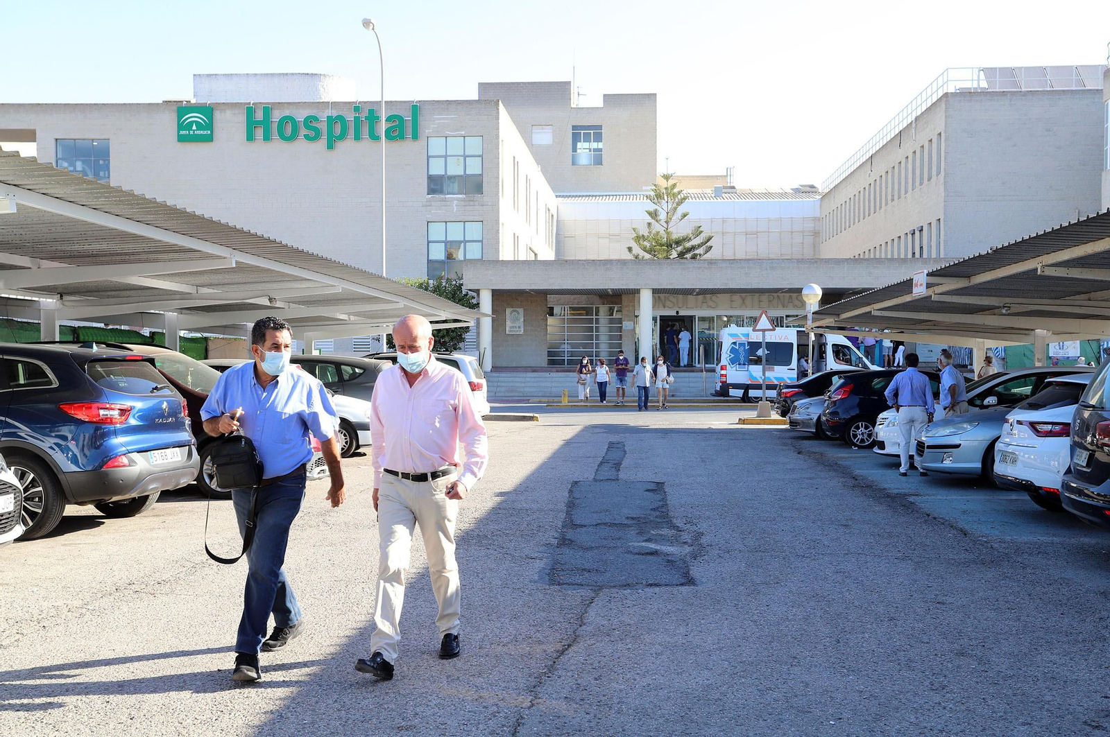 Dos personas caminan por los aparcamientos del recinto del hospital Juan Ramón Jiménez en la mañana de ayer.