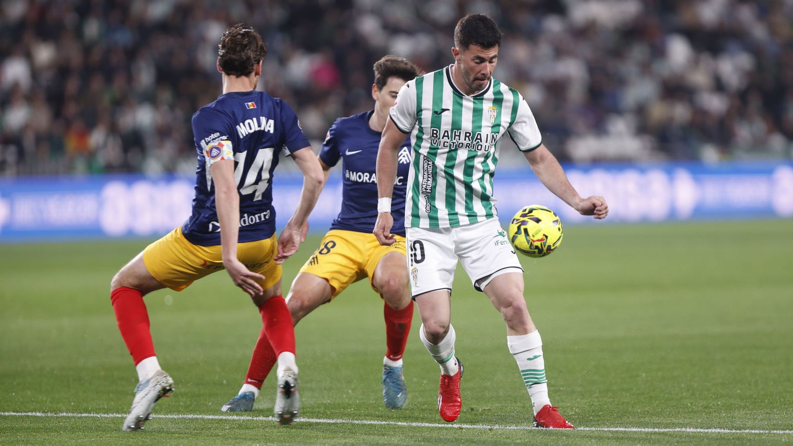 Jacobo controla el balón ante dos jugadores del Andorra.