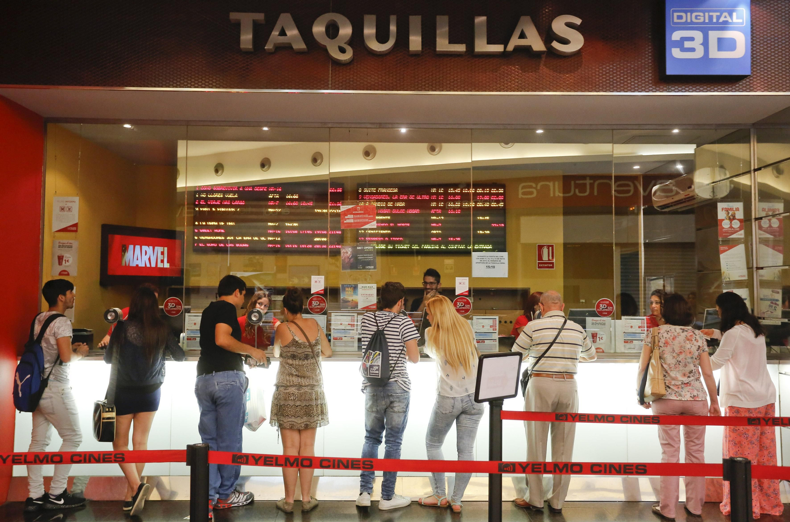 Público haciendo cola en las taquillas de un cine.