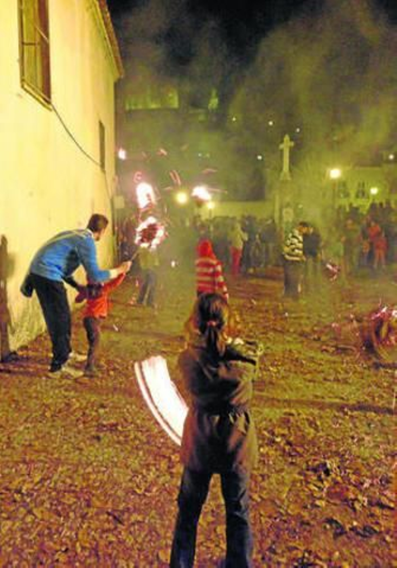 Los niños, moviendo las varas de castaño incendiadas.