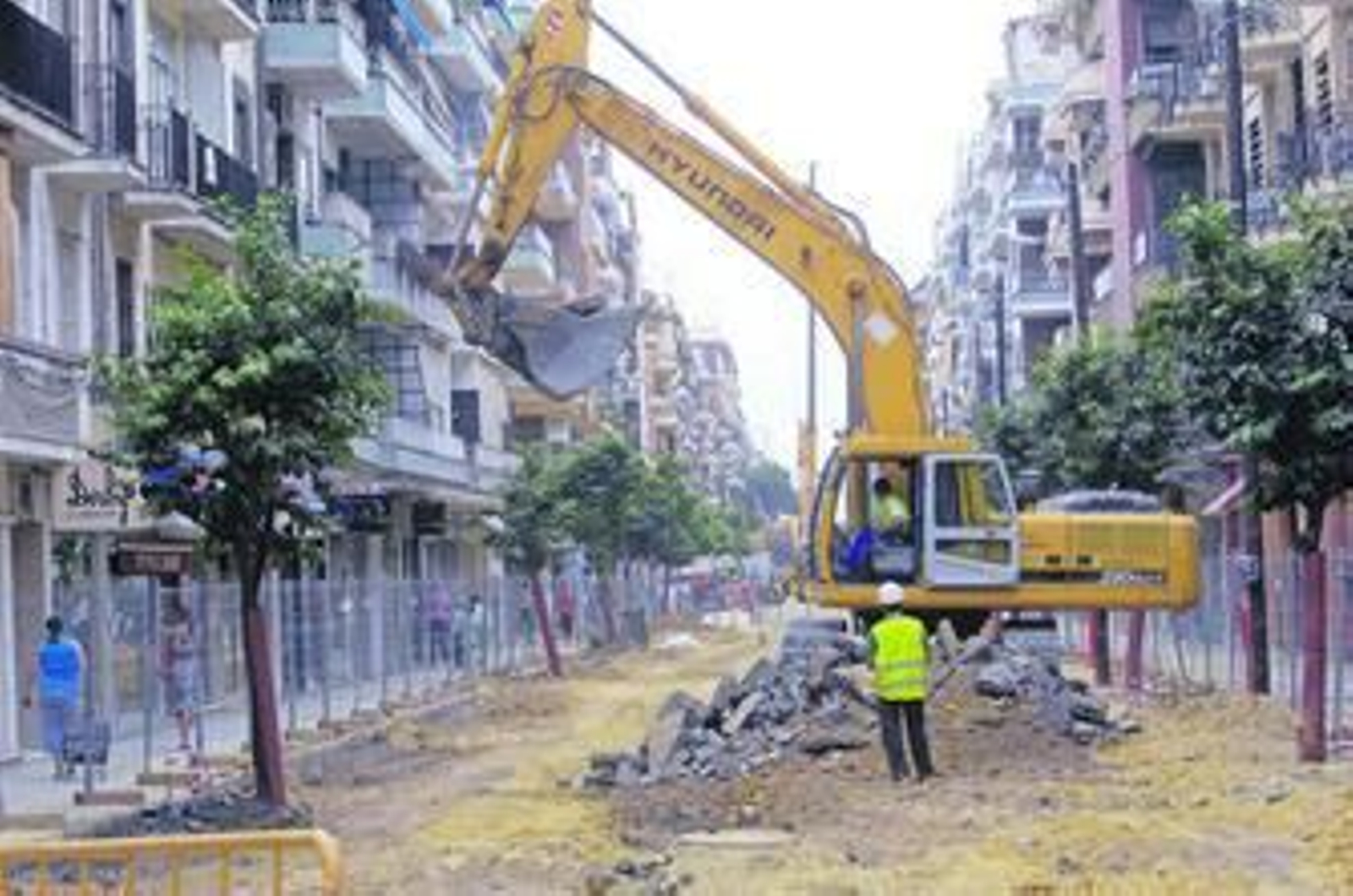 Una gruista recoge restos de calzada en las obras de la calle Asunción, ayer.