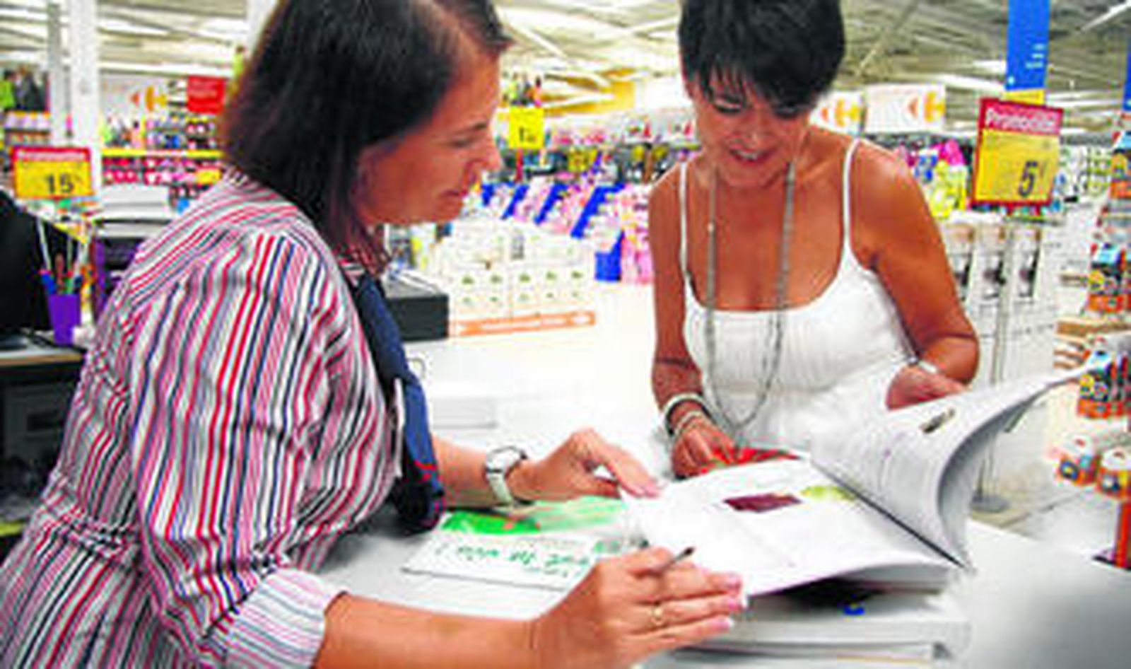 Una madre comprueba el material escolar con una dependienta de un centro comercial donde en plena campaña de la vuelta a clase.