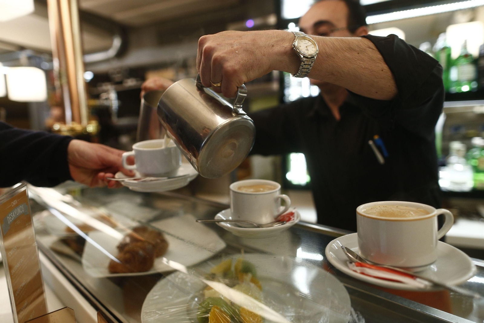 Un camarero sirve un café en un bar. Un camarero sirve un café en un bar.