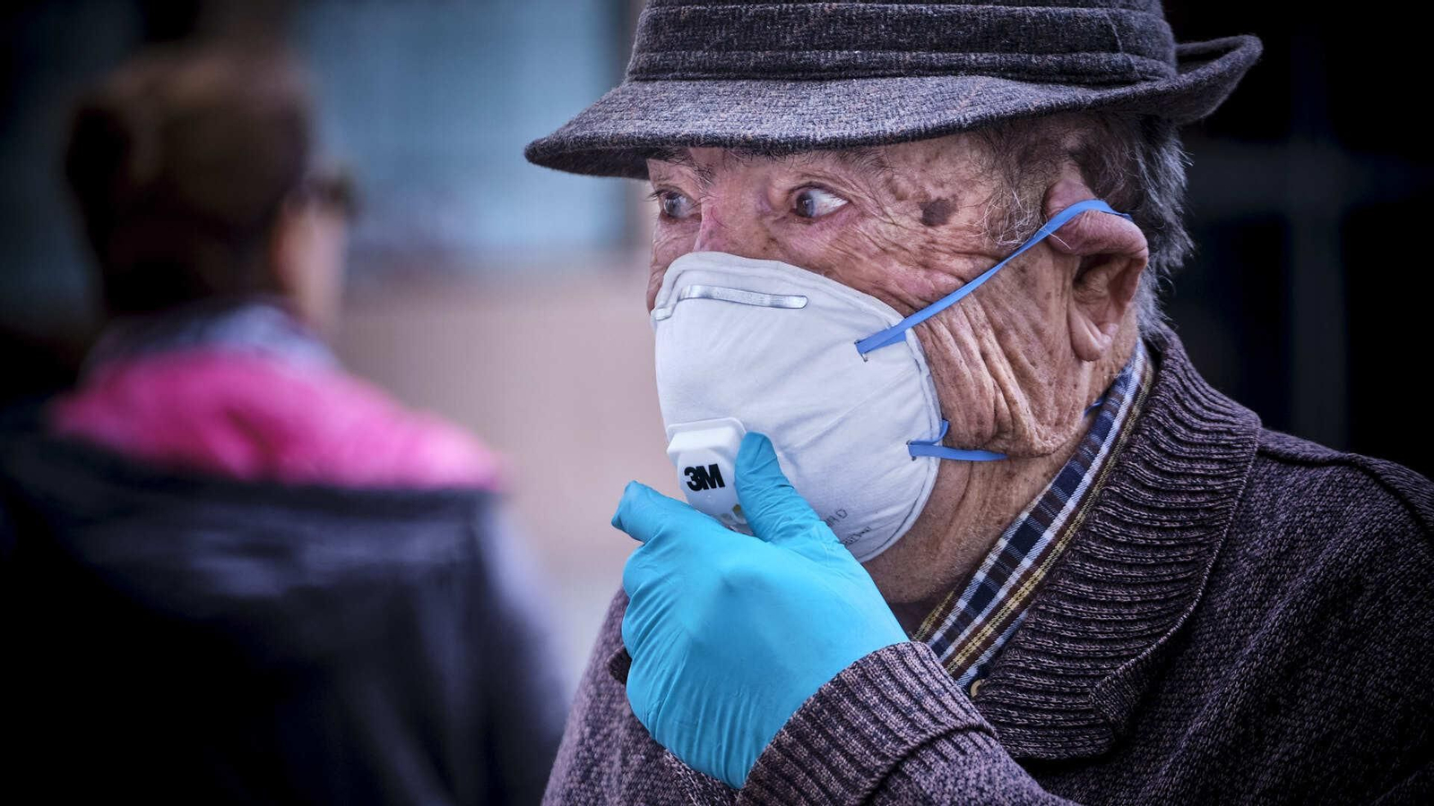 Una persona mayor protegida con mascarilla FFP2 y guantes