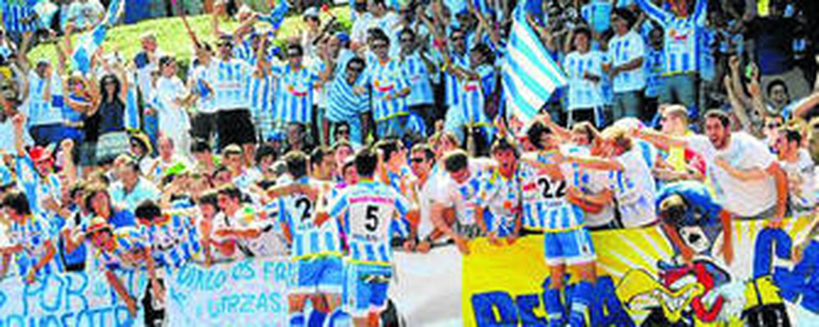 Aficionados de la Arandina abrazan a jugadores en un partido.