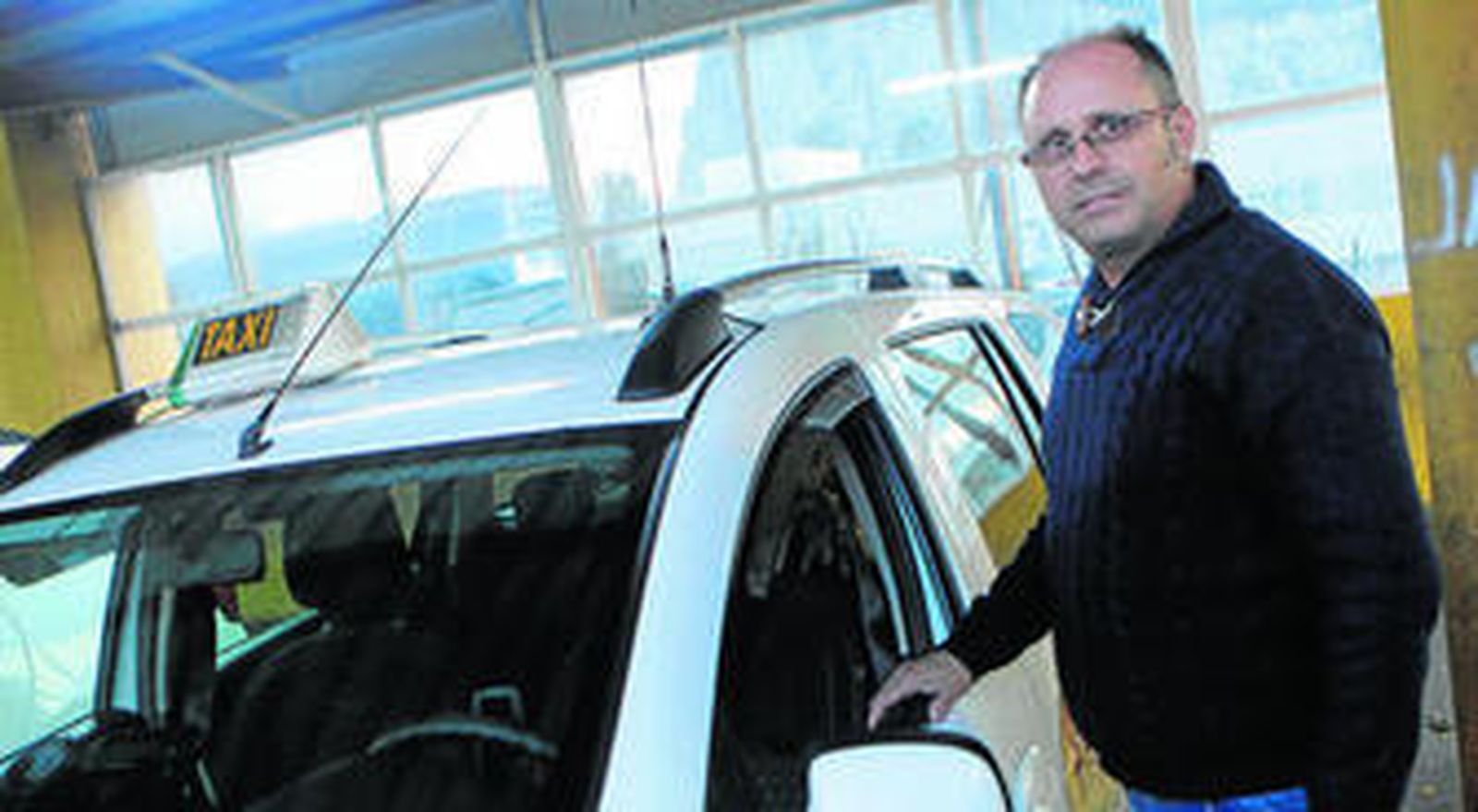 José Álvarez, junto a su taxi, en la parada que hay en la frontera con Gibraltar.