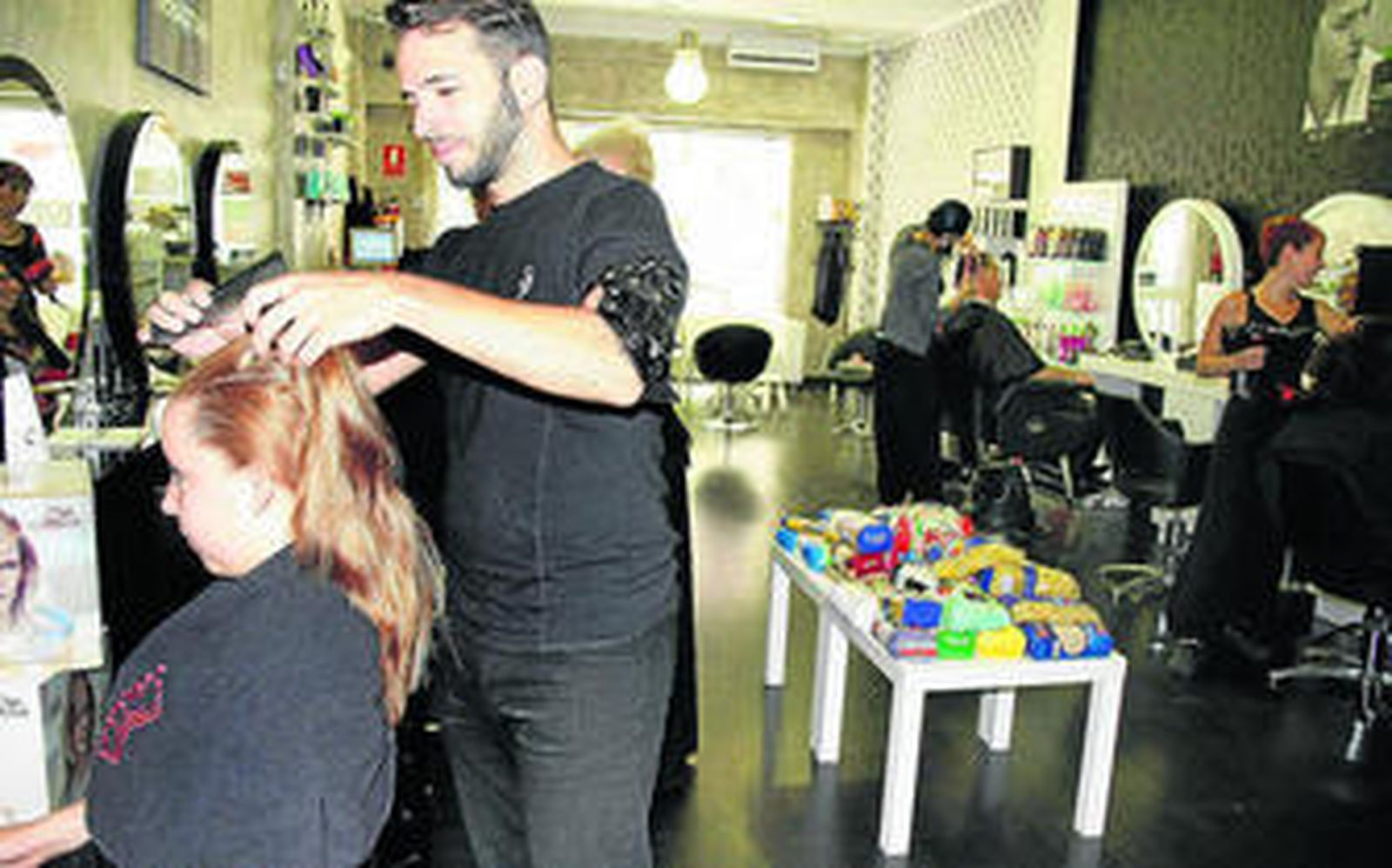 Uno de los peluqueros de Paranoia, ayer atendiendo a una de las clientas que acudió al establecimiento.
