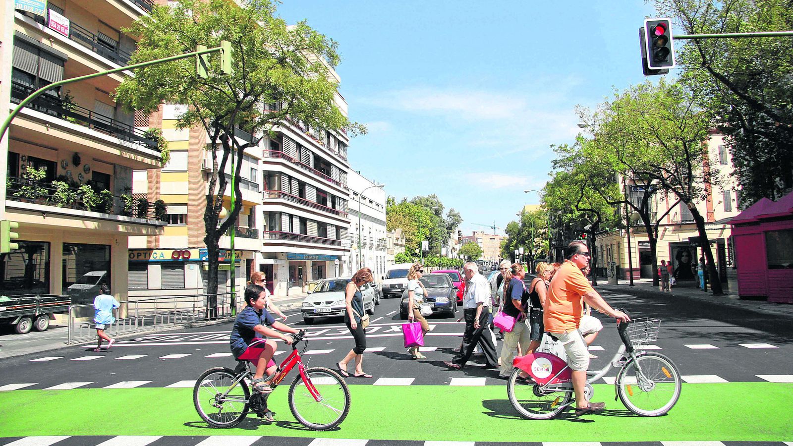 Un niño y un adulto circulando por Sevilla en bicicleta.