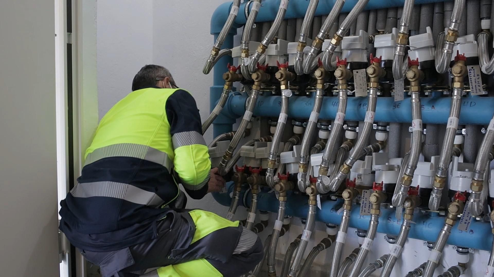 Un operario trabajando en unos contadores  digitales de agua.