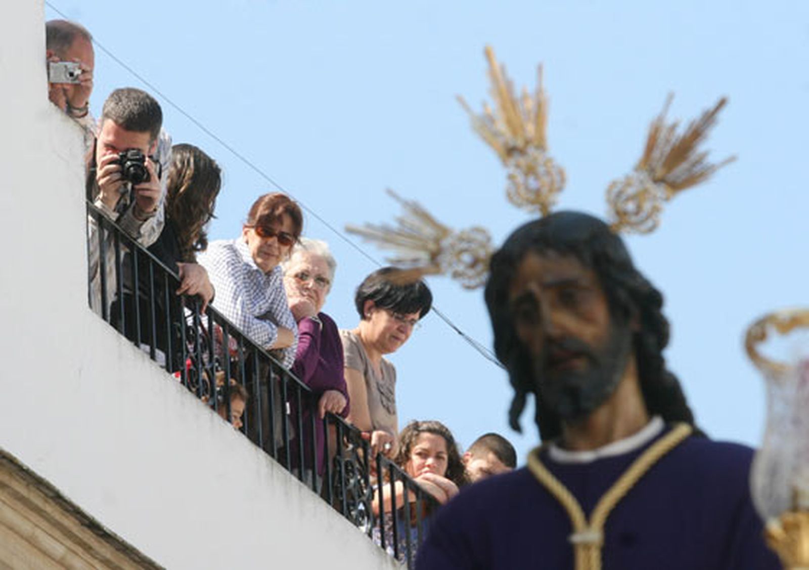 Detalle del Cautivo con varios sevillanos en un balcón al fondo.

Foto: Belén Vargas