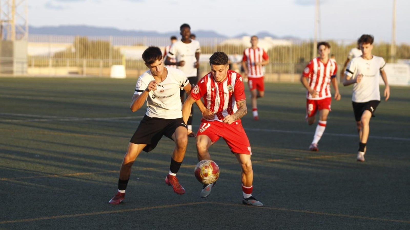 Pugna de balón entre dos futbolistas en el derbi almeriense.