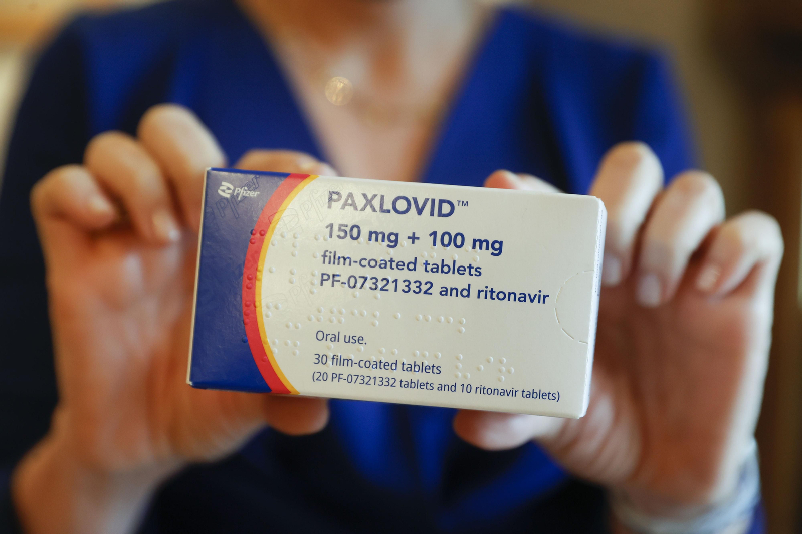 Una farmacéutica muestra una caja de Paxlovid , el antiviral oral contra el Covid que se vende en farmacias.