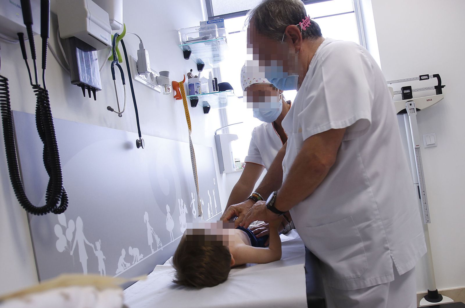 Dos profesionales atienden a un niño.