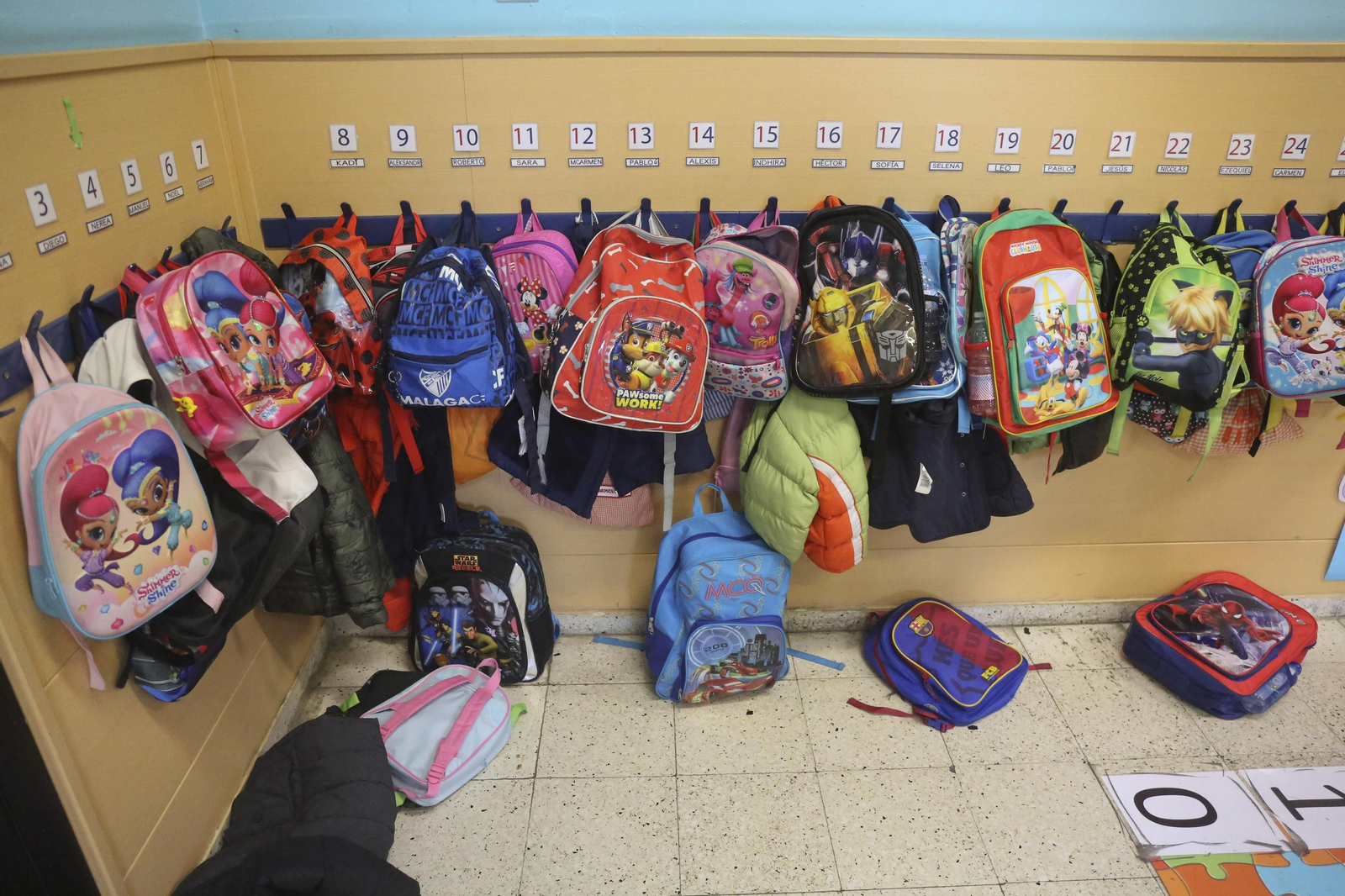 Mochilas de alumnos de infantil colgadas en un aula.