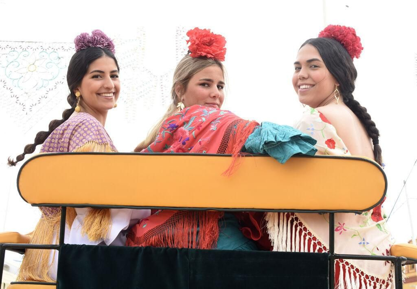 Tres jóvenes en un carruaje en la Feria de Nuestra Señora de la Salud.