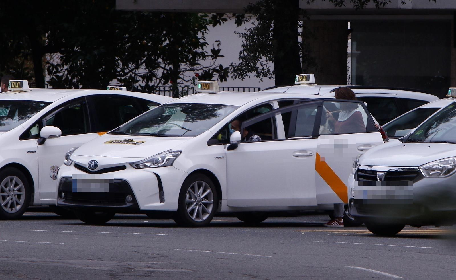 Una mujer se monta en un taxi en una parada.