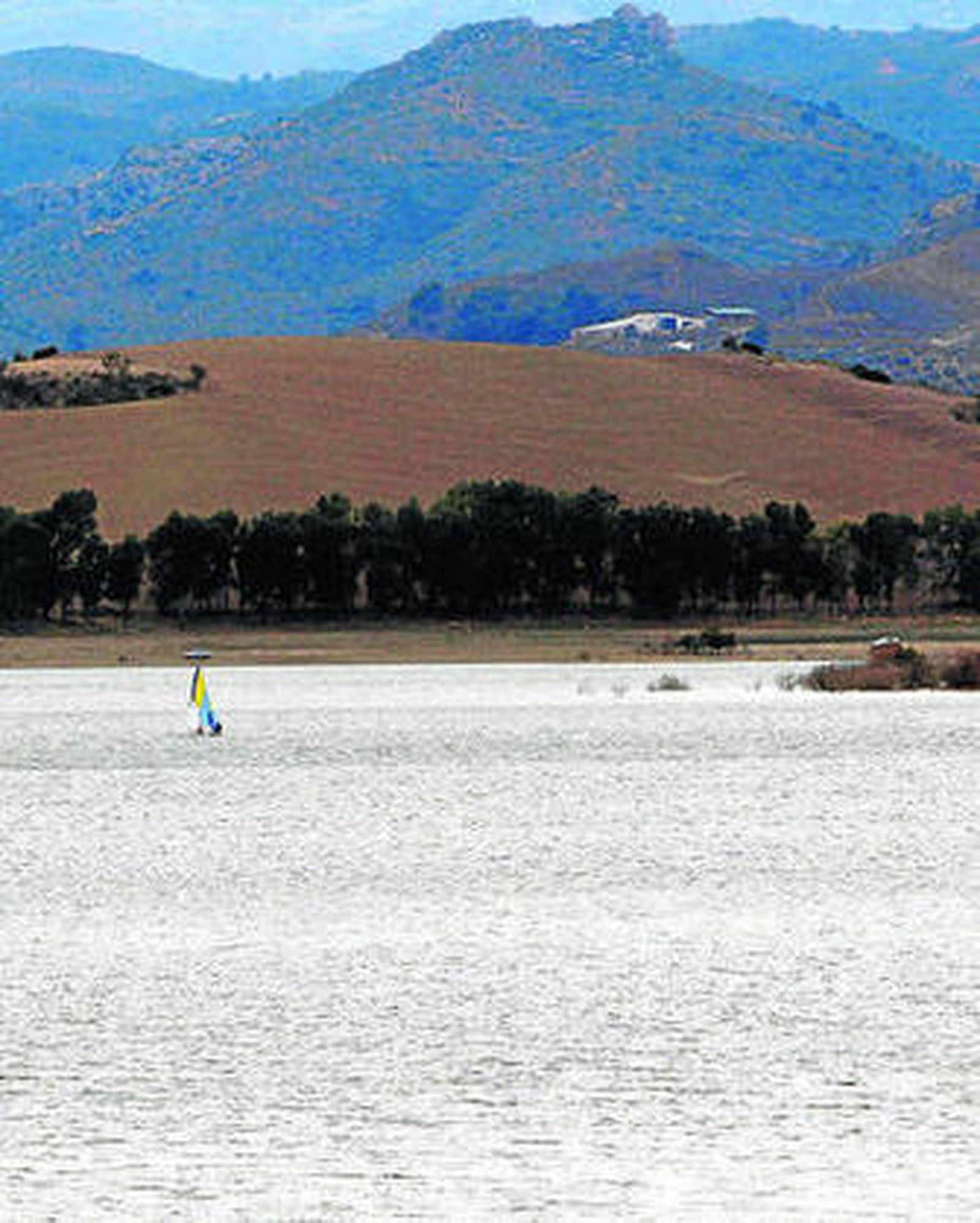 Al fondo se observa una embarcación de vela, en uno de los pantanos.