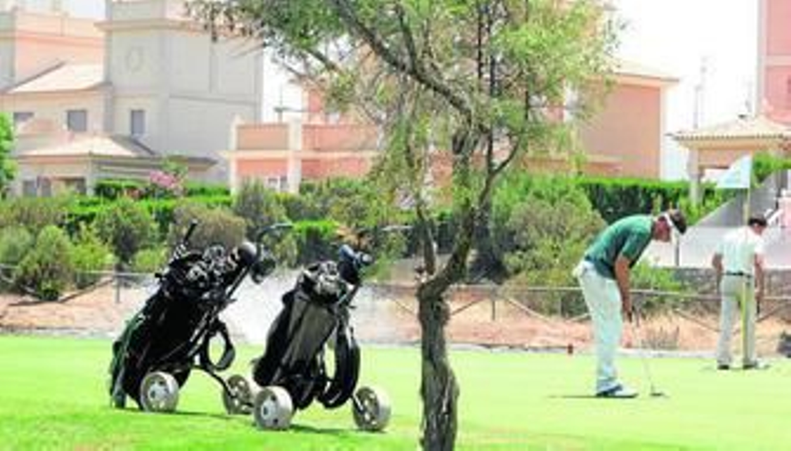 Dos jugadores practican golf en las instalaciones del campo Dunas de Doñana.