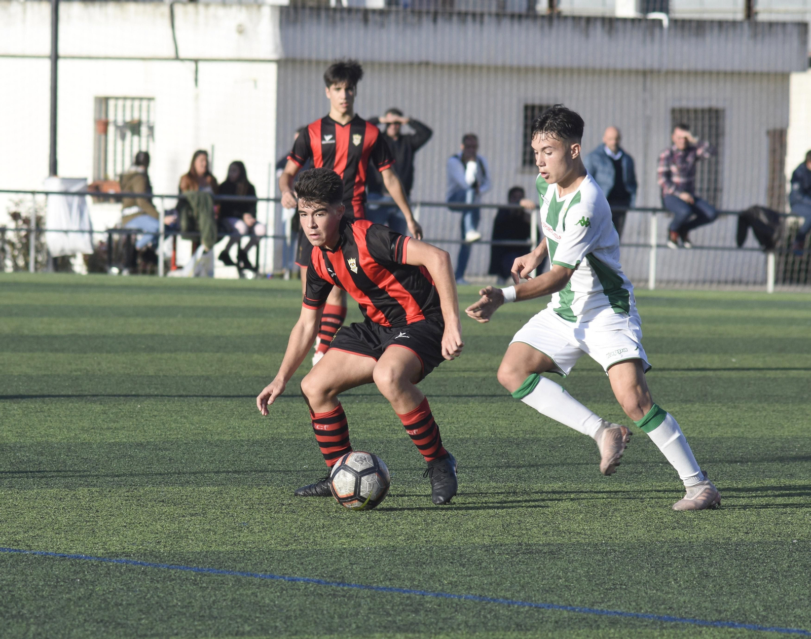 Un jugador del Séneca escapa con el balón ante la presión de uno del Córdoba.