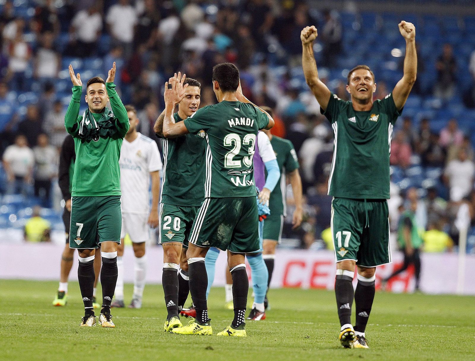 Jugadores béticos celebrando la victoria en el Bernabéu.