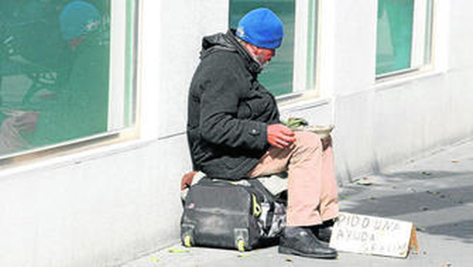 Un 'sin techo', pidiendo ayuda en una calle céntrica de Jerez.