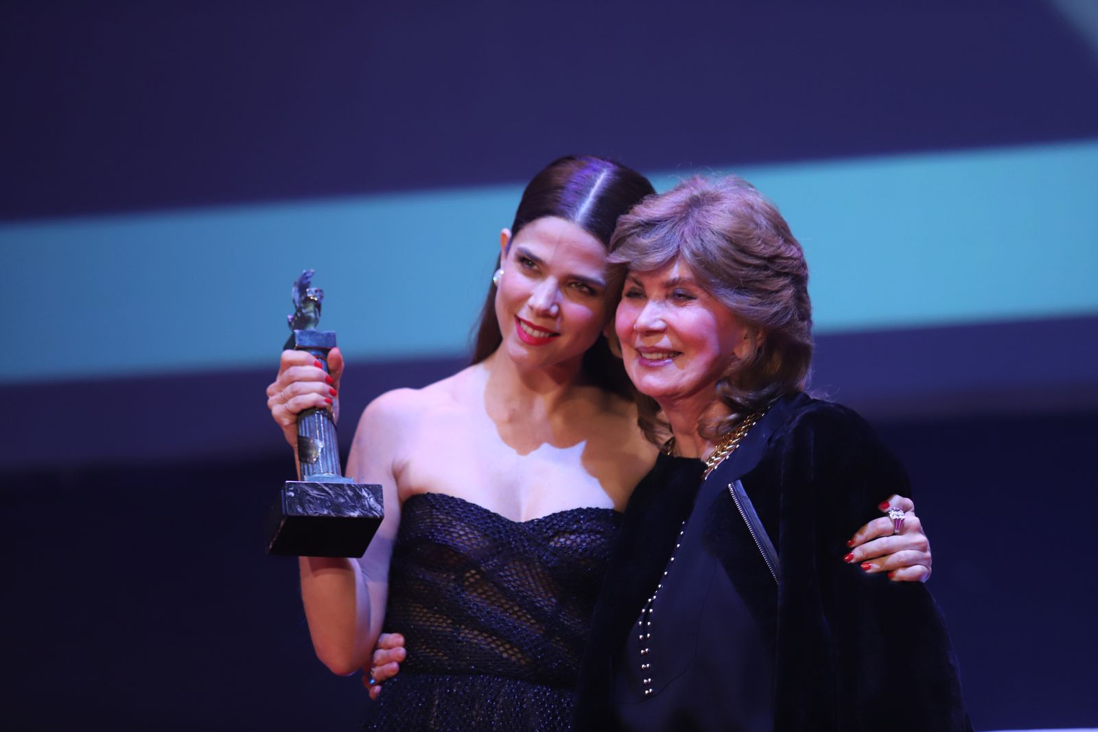 La actriz colombiana Juana Acosta recibe el premio Ciudad de Huelva junto a su madre.