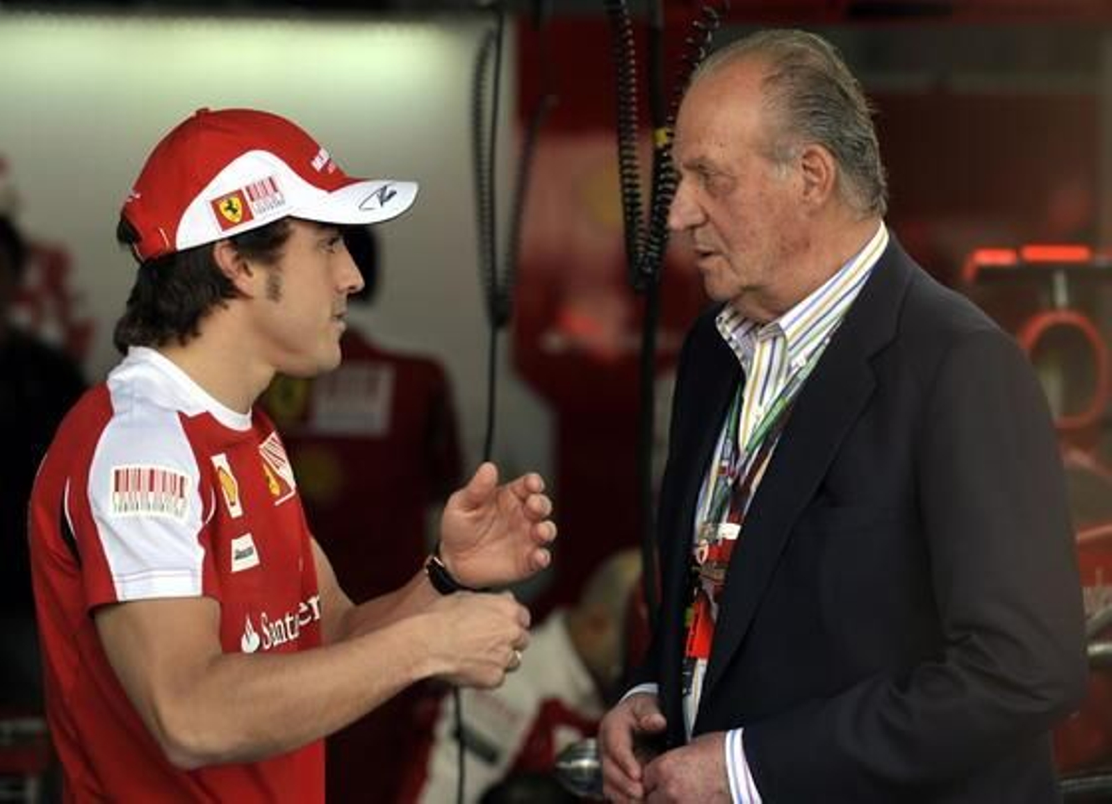 Fernando Alonso departe con el rey Juan Carlos antes de la carrera. / AFP