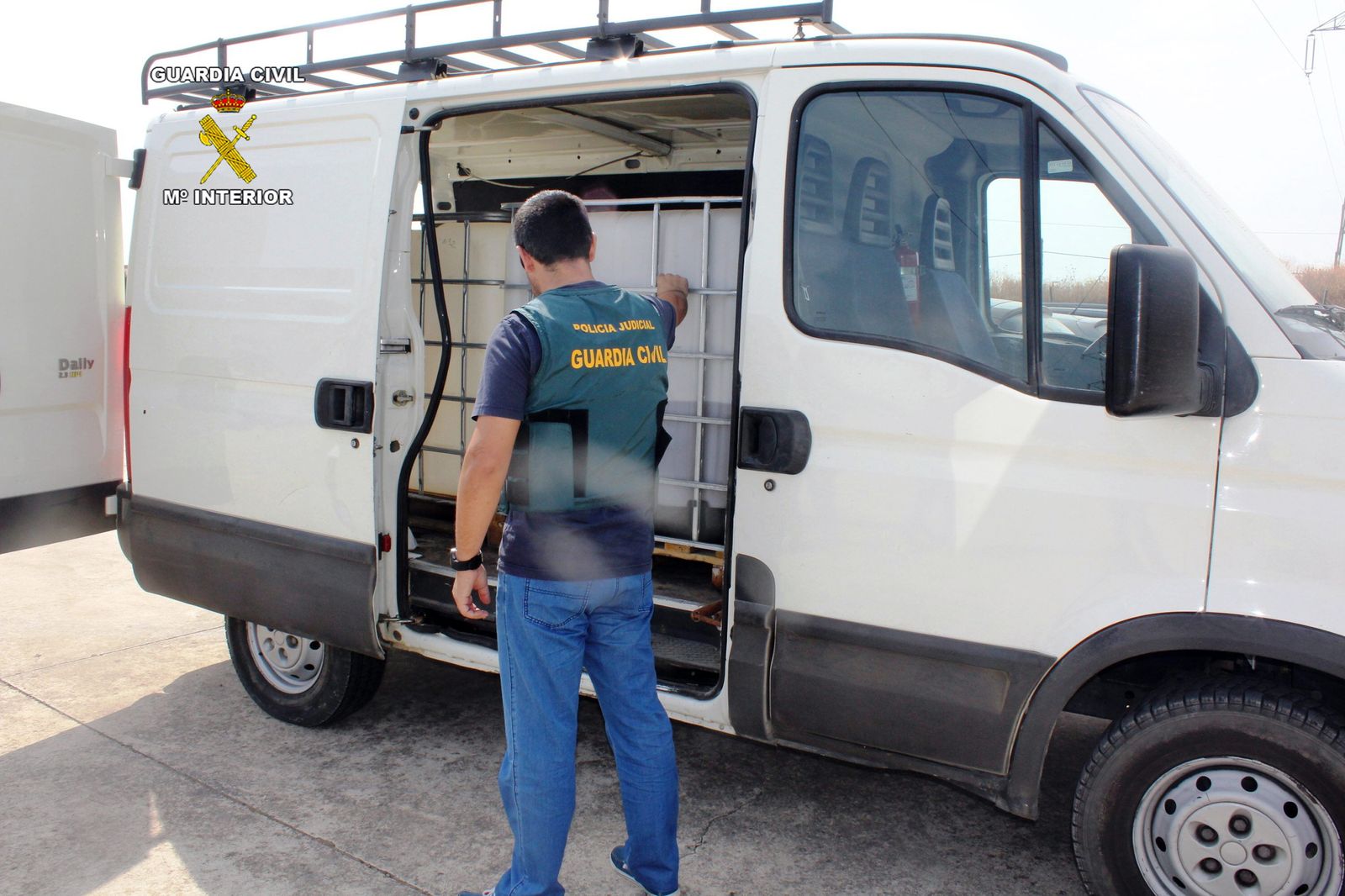 Un agente de la Guardia Civil con una de las furgonetas intervenidas