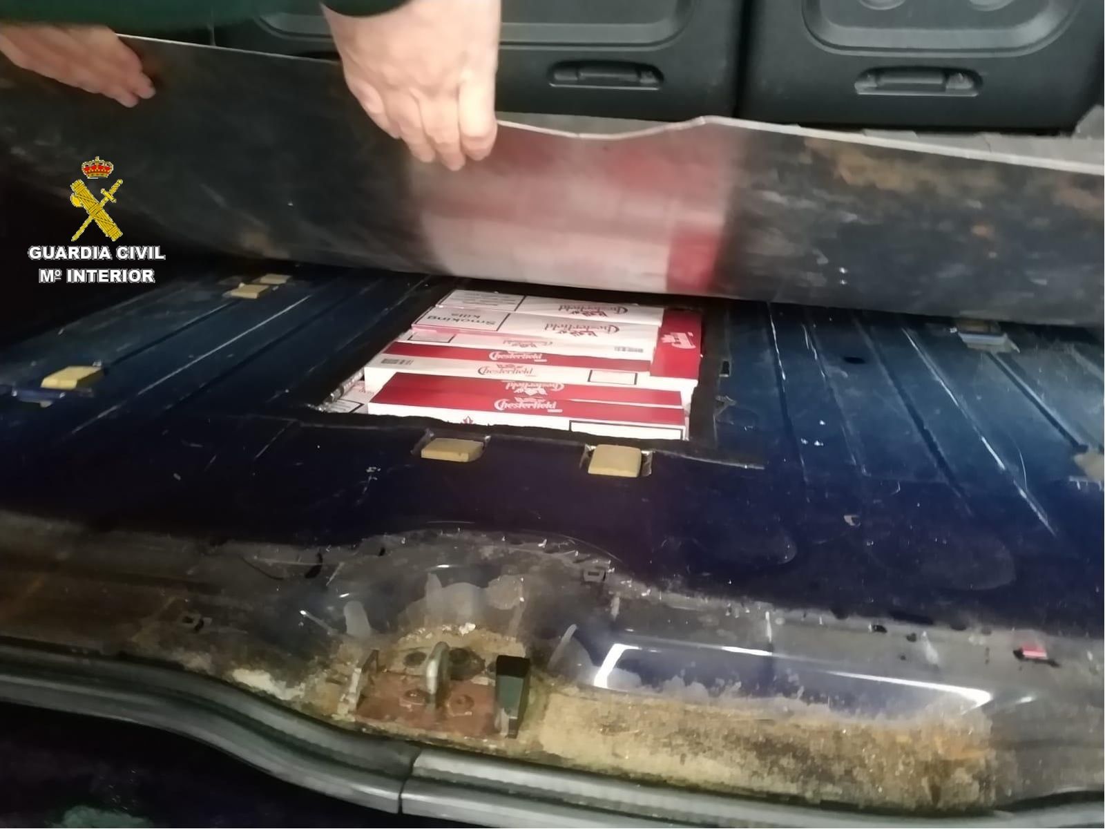 Un guardia civil muestra uno de los huecos que ocultaban el tabaco de contrabando.