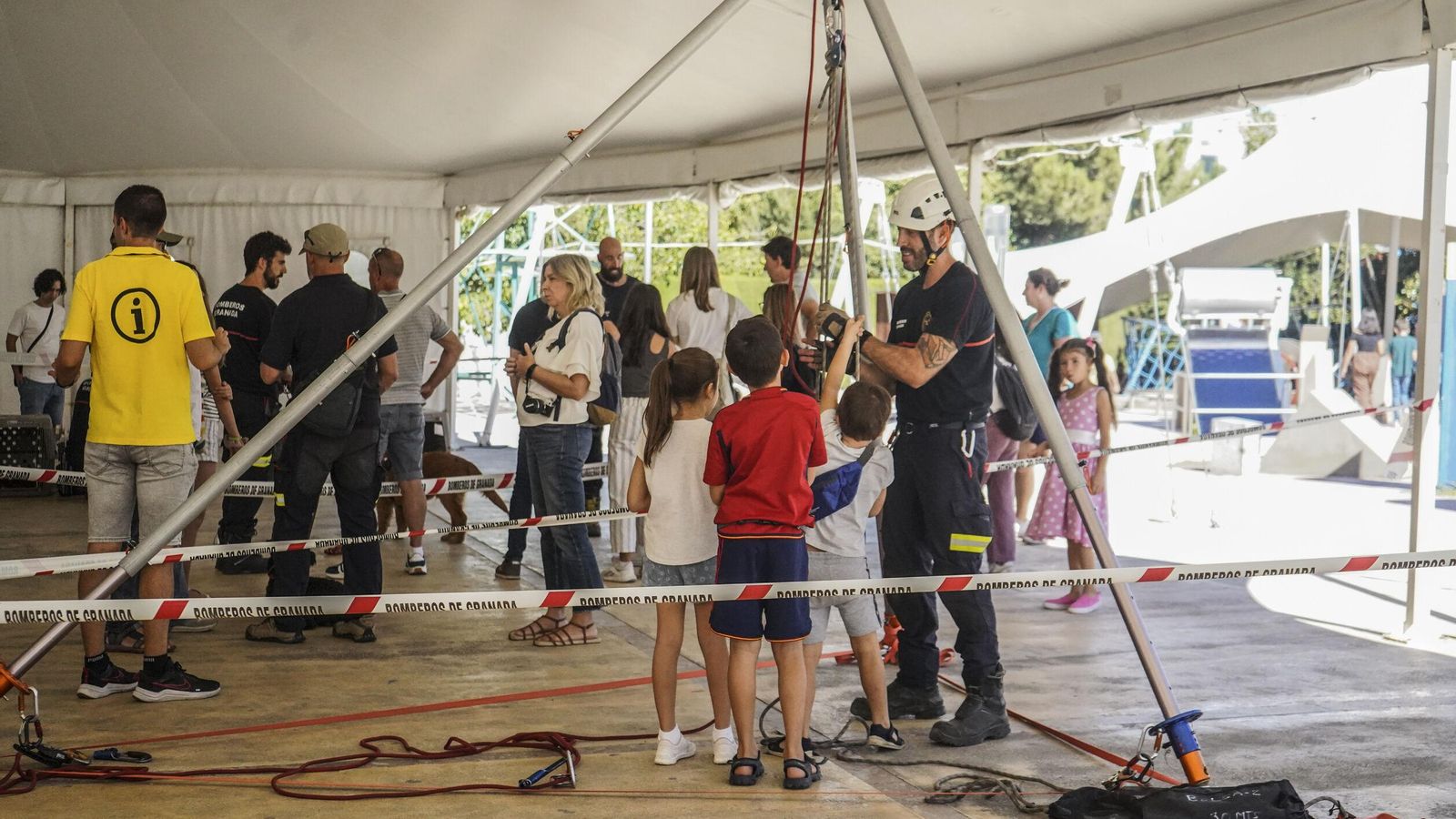 Unos niños se interesan por el equipo de poleas para levantar grandes pesos Unos niños se interesan por el equipo de poleas para levantar grandes pesos
