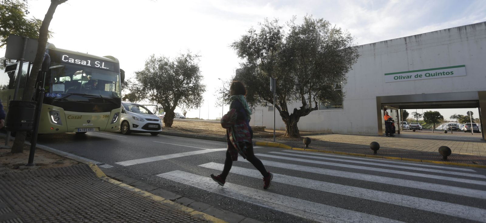 Una mujer camina por el paso de peatones situado frente a la estación de Metro Olivar de Quintos.