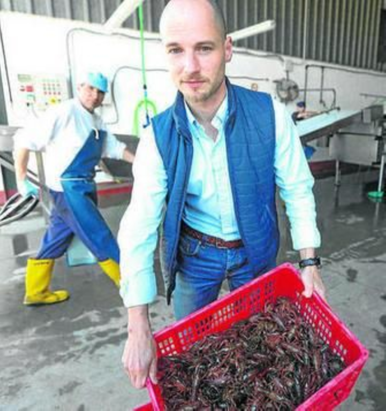 Un empresario muestra una caja con cangrejo rojo.