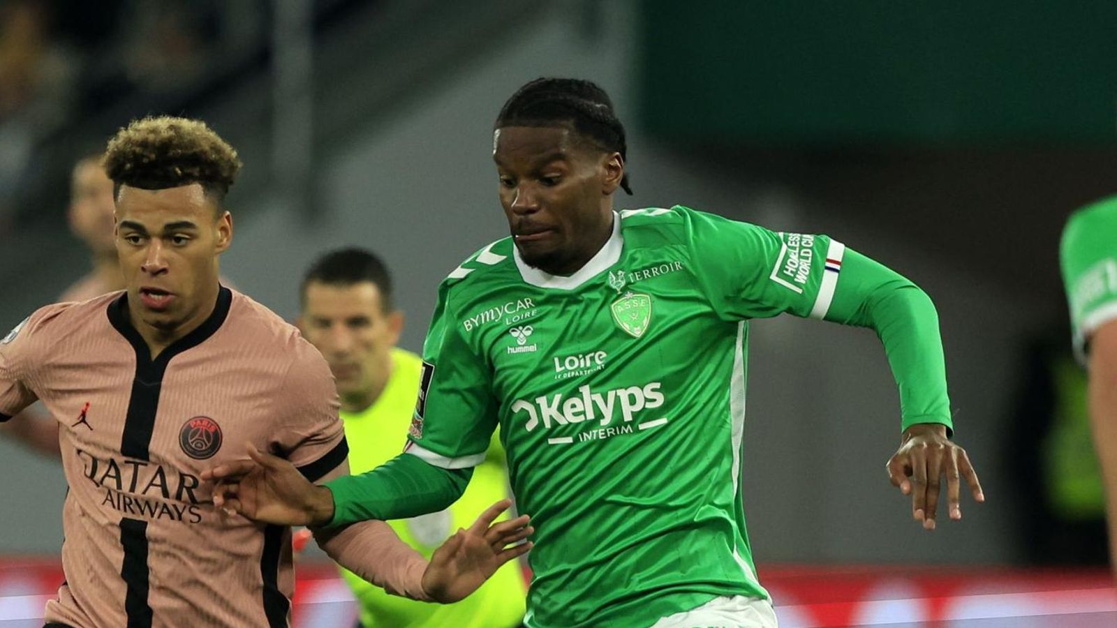 Pierre Ekwah presiona a Doue en un partido del Saint-Étienne ante el PSG.