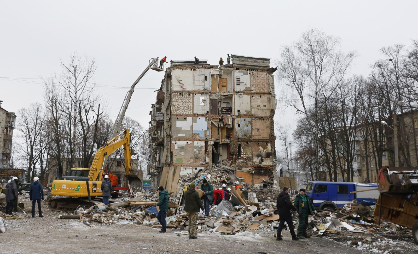 Operarios ucranianos limpian escombros en un edificio destruido por los ataques rusos en Jarkov.