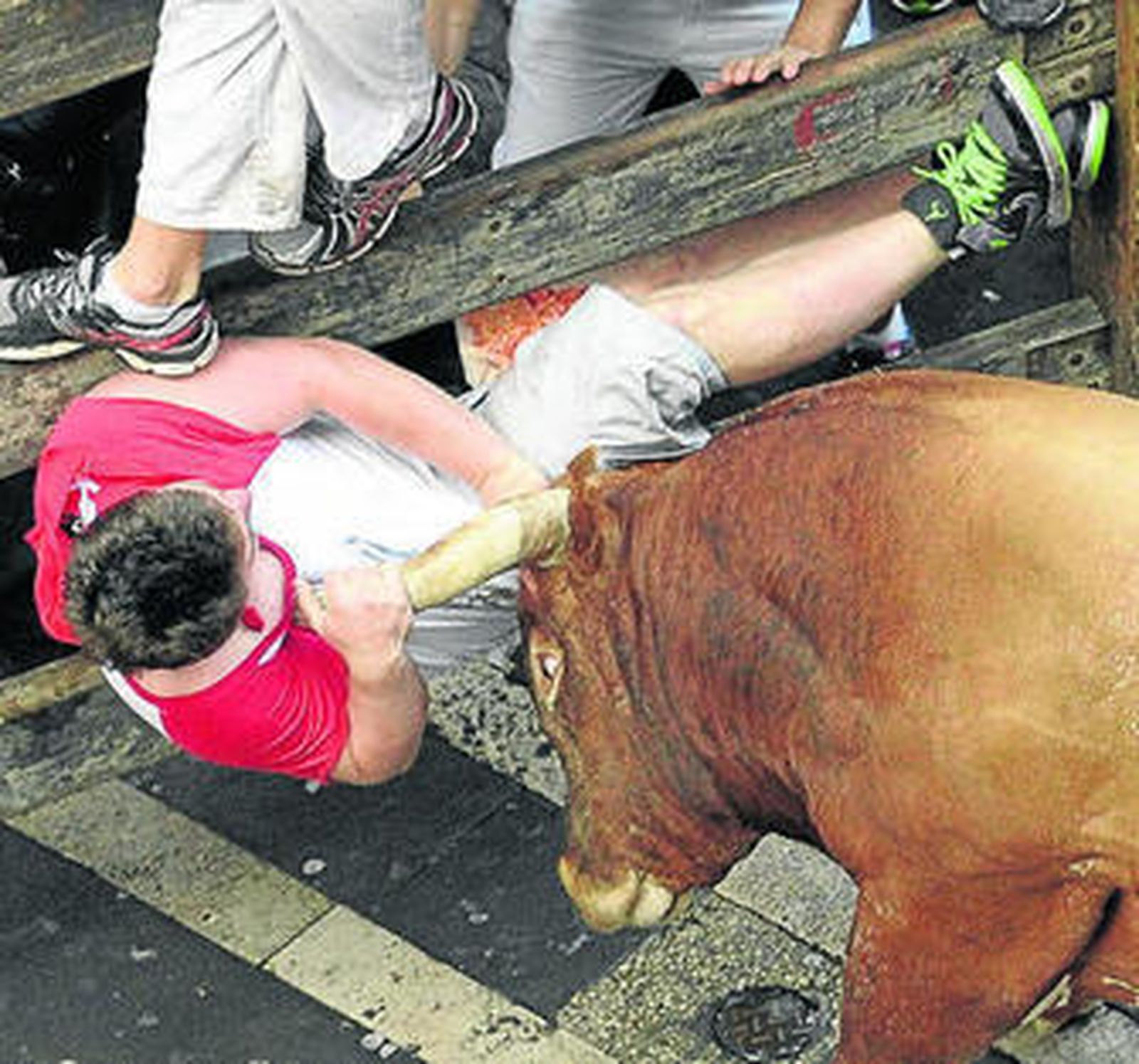 El toro 'Olivito' embiste a un mozo en la calle Estafeta.