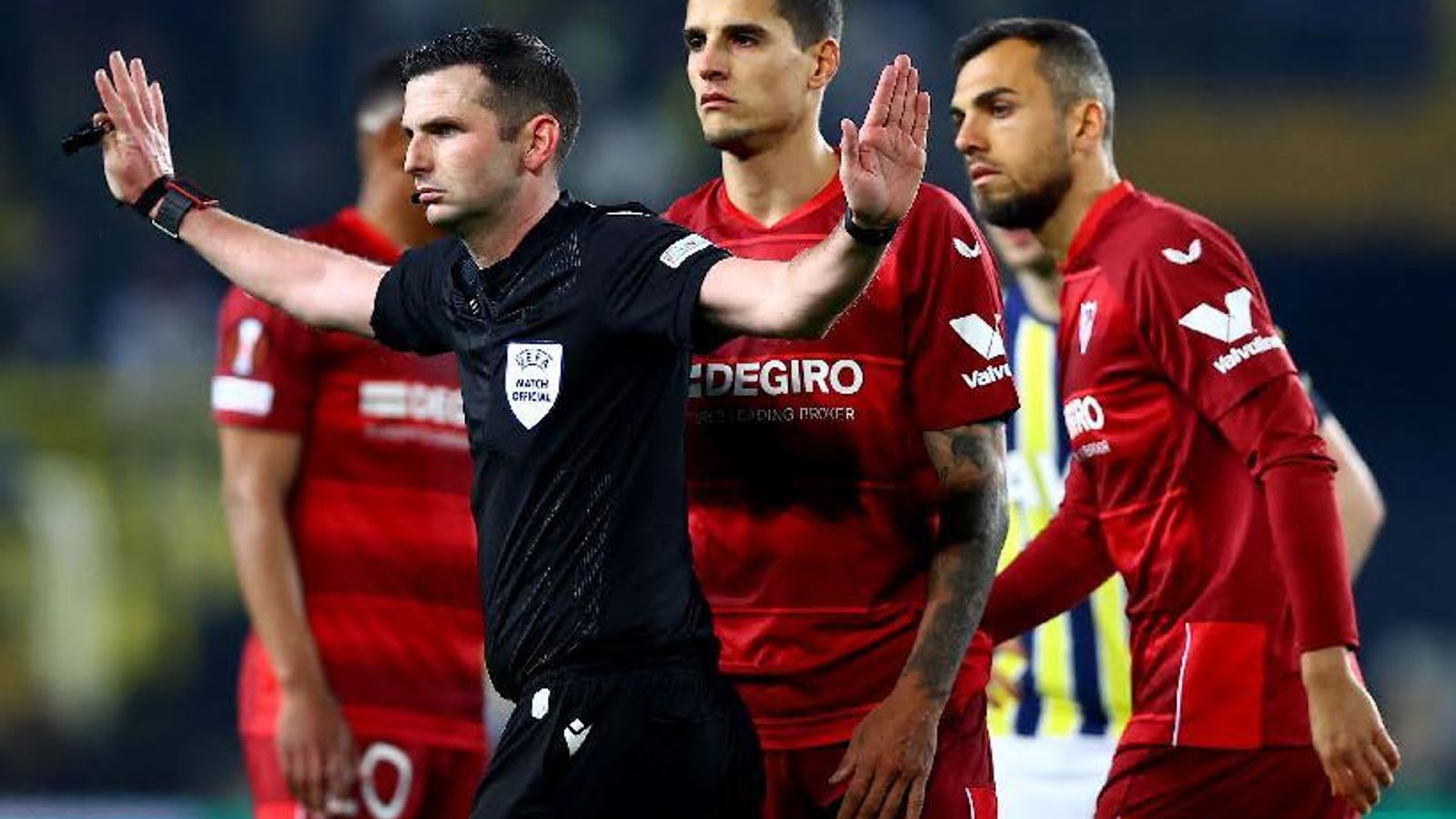 El árbitro Michael Oliver se muestra firme tras varios sevillistas.