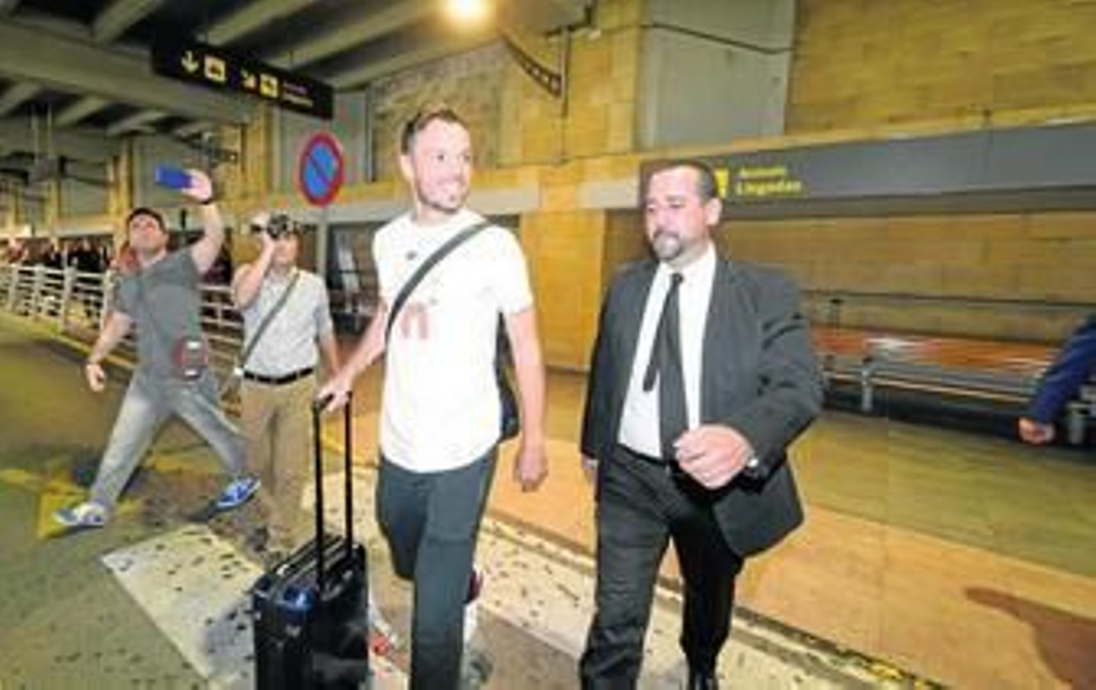 El defensa alemán Westermann, acompañado de un empleado de seguridad del club.