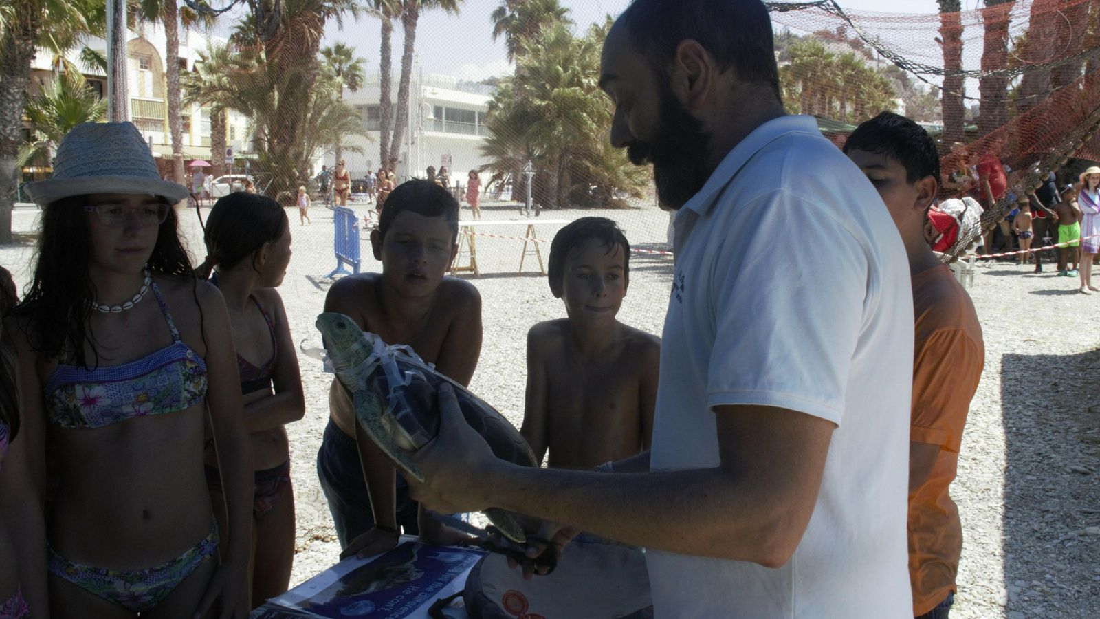 Los niños participantes atienden a la explicación sobre las tortugas y los plásticos Los niños participantes atienden a la explicación sobre las tortugas y los plásticos