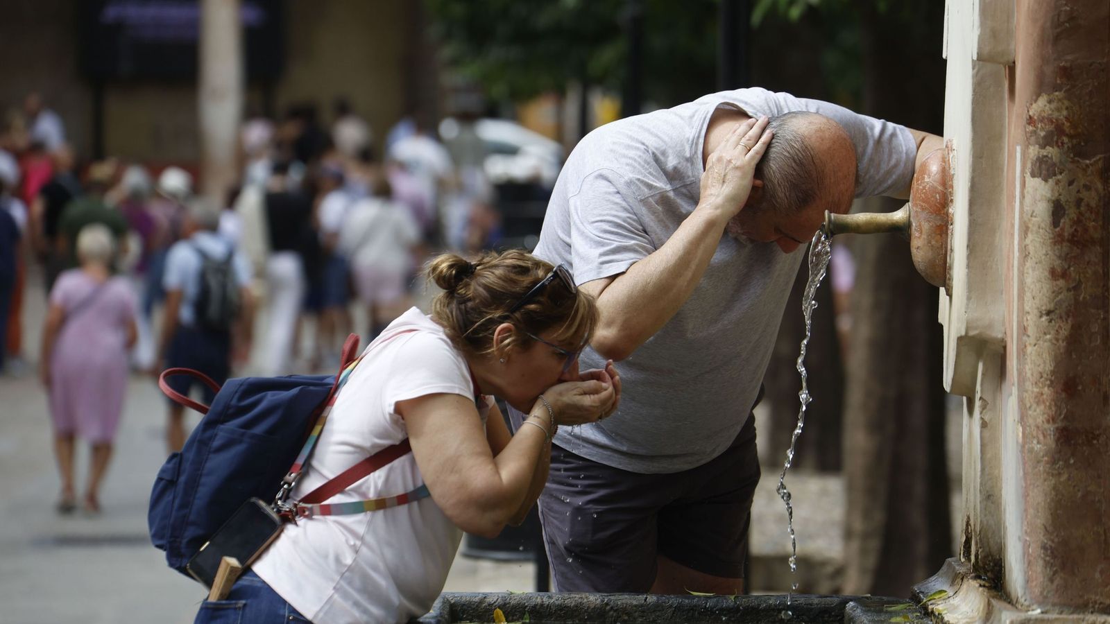 Turistas se refrescan en una fuente del Patio de los Naranjos.