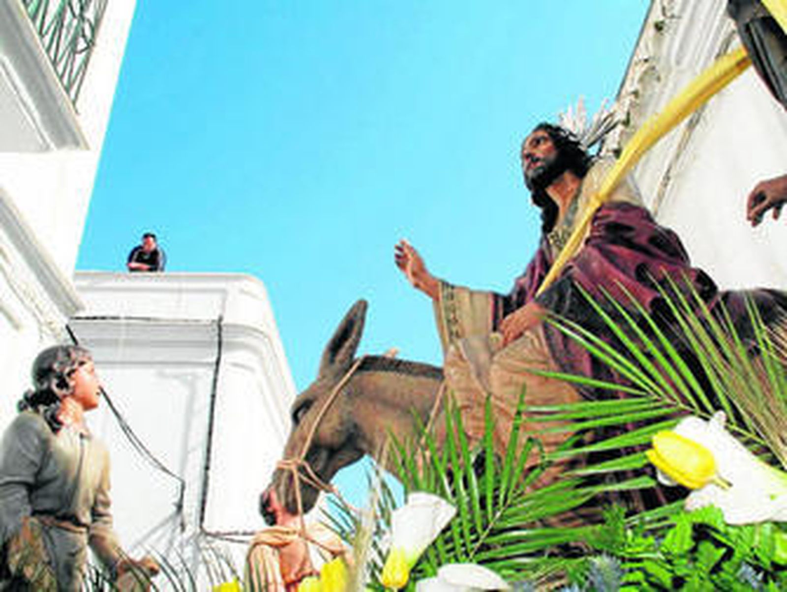El paso de La Borriquita de Tarifa avanza por las angostas calles del casco histórico.