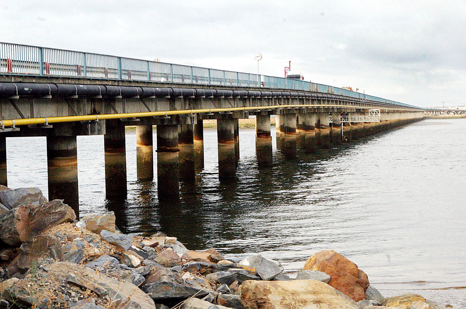 Imagen panorámica de archivo del puente sifón Santa Eulalia al otro lado del Odiel con tuberías en su lateral.