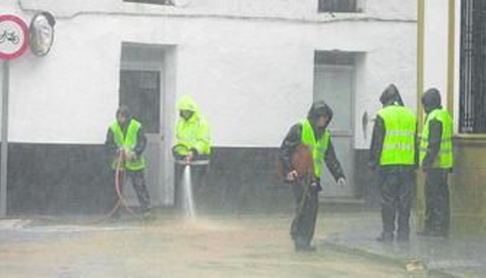 Operarios municipales de Constantina limpian una de las calles inundadas, ayer por la mañana.