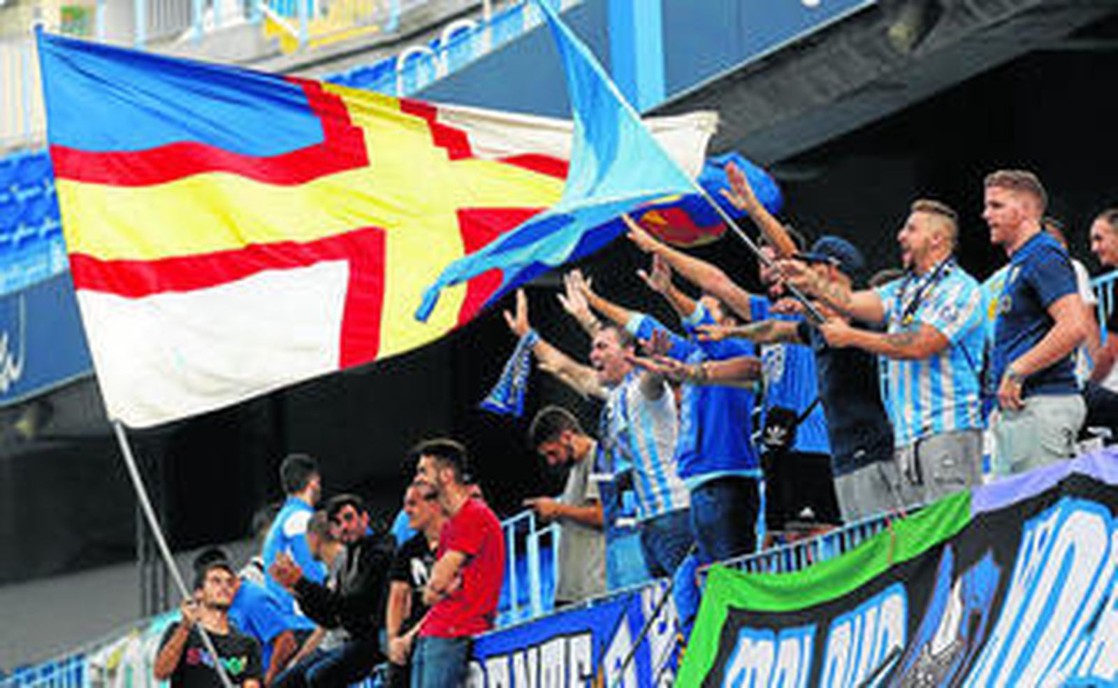 Un grupo de aficionados ondea sus banderas durante el partido.