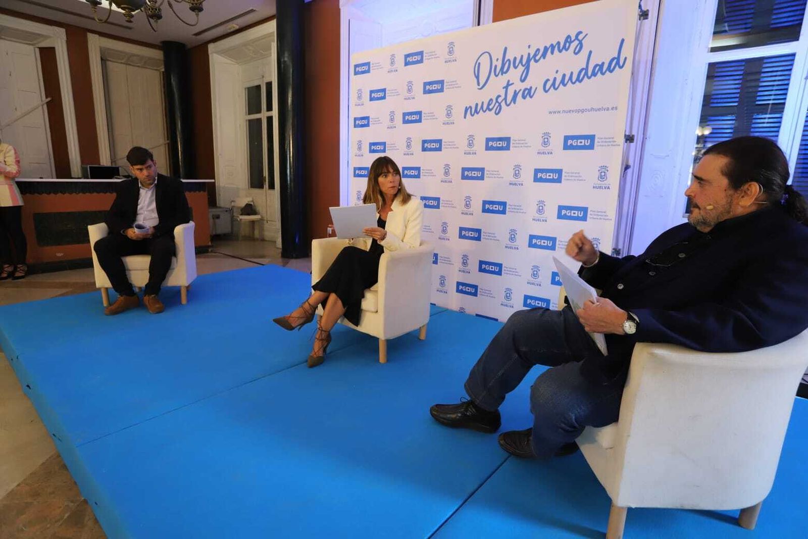 Dos responsables de la consultora presentan la fase de participación del nuevo PGOU acompañados por la presentadora del acto, Ana Virginia Gutiérrez.