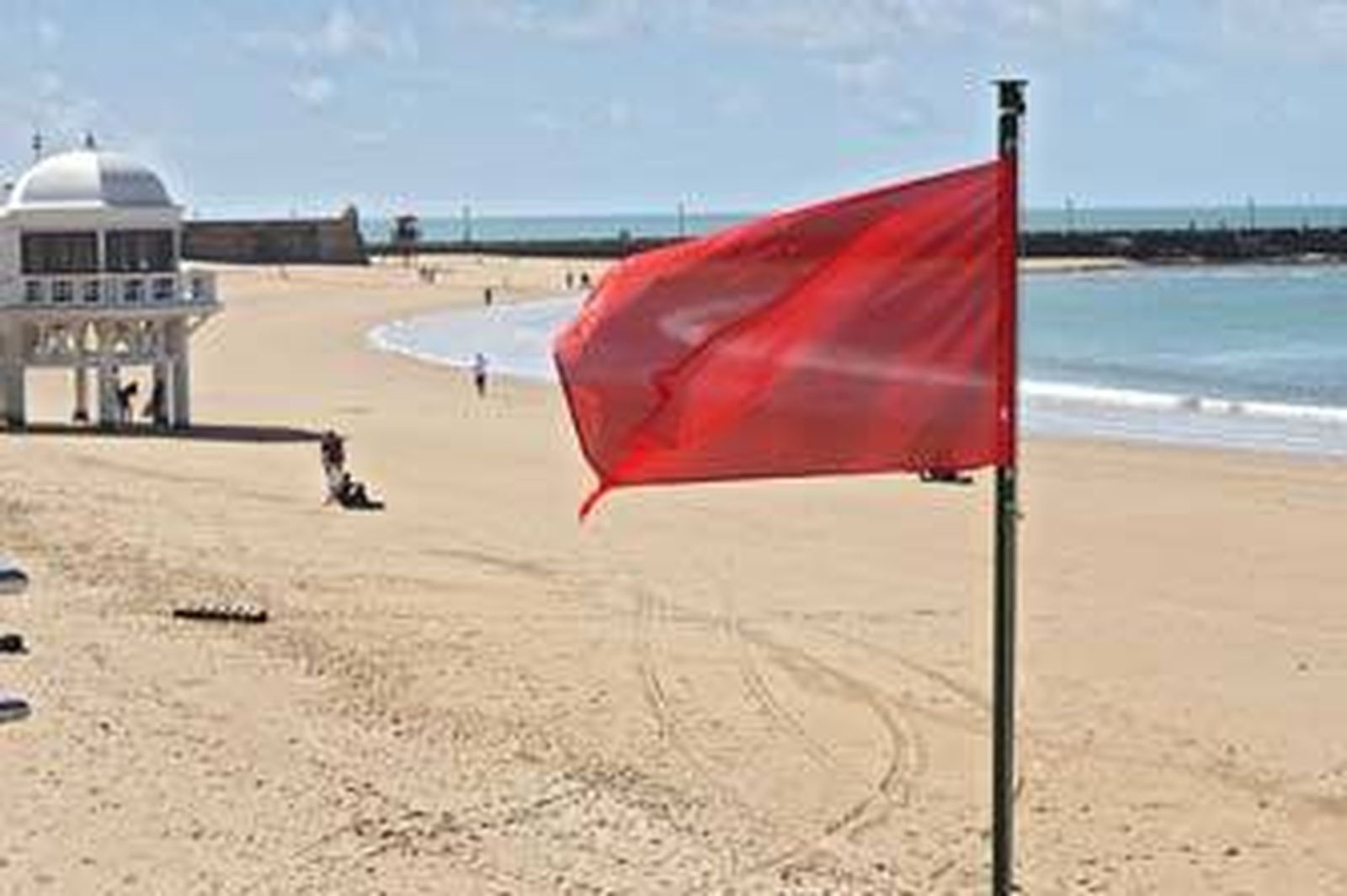 La playa de La Caleta, ayer, con la bandera roja ondeando al viento. /Joaquín Pino