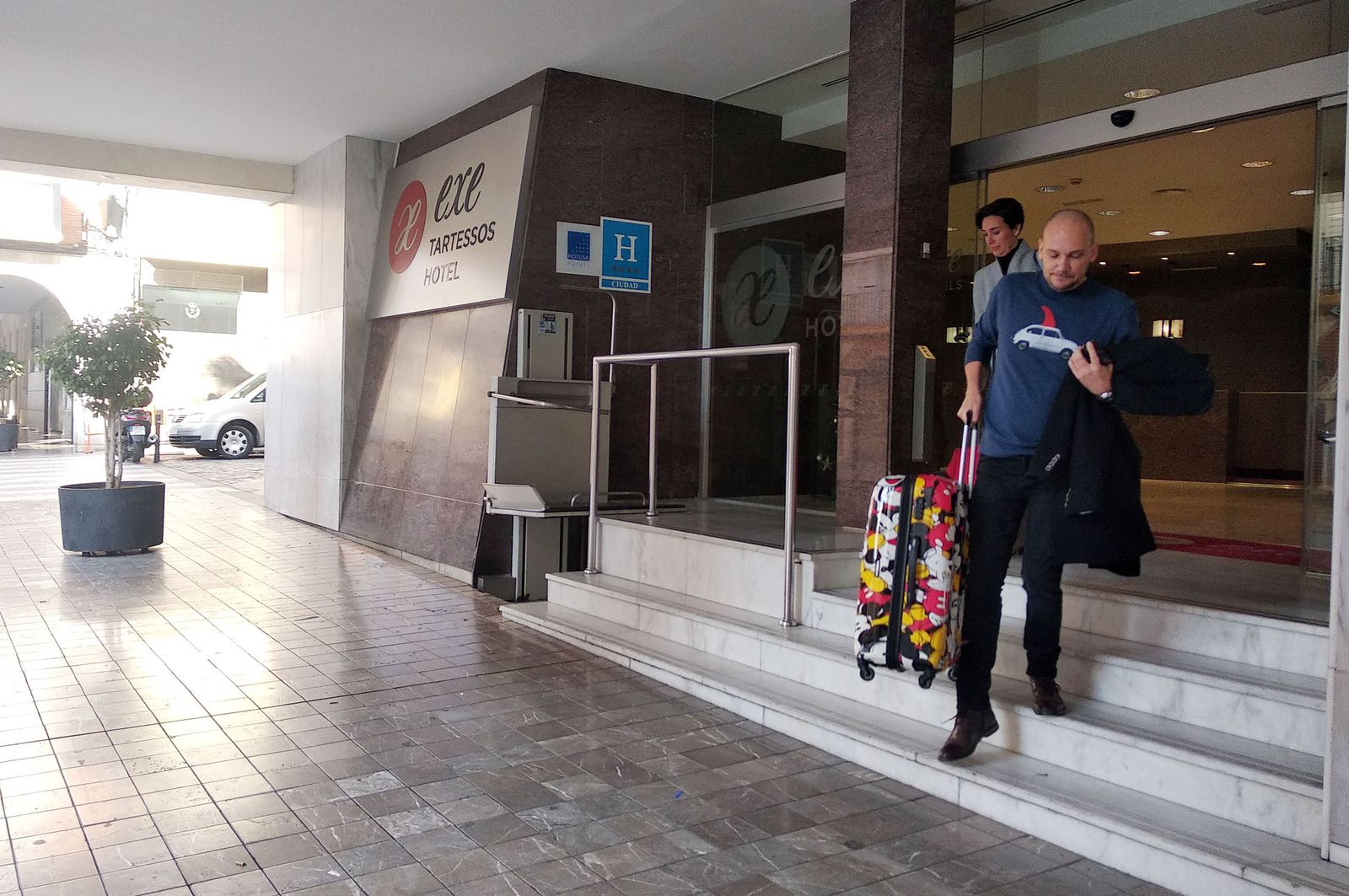 Dos turistas salen del Hotel Tartessos de la capital onubense.