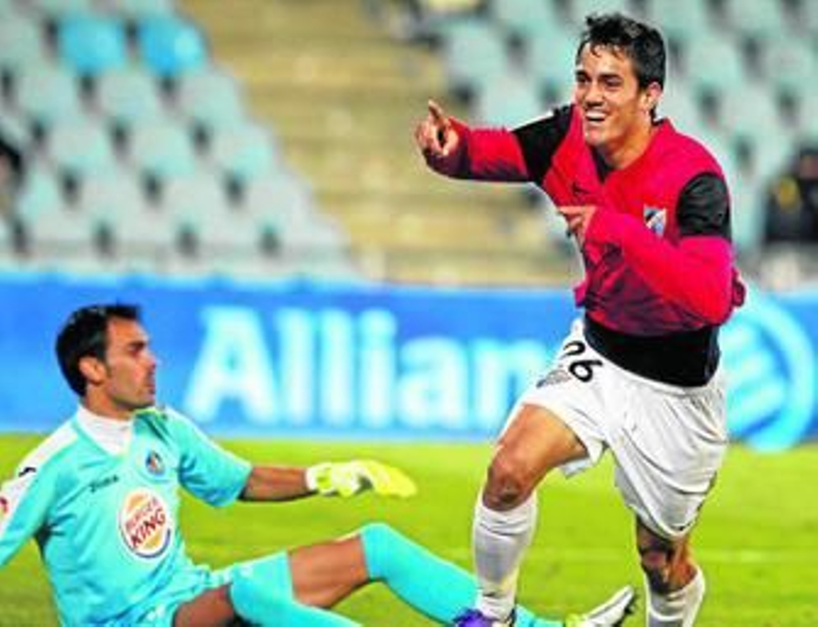 Juanmi celebra el gol con Codina, batido, en el suelo.
